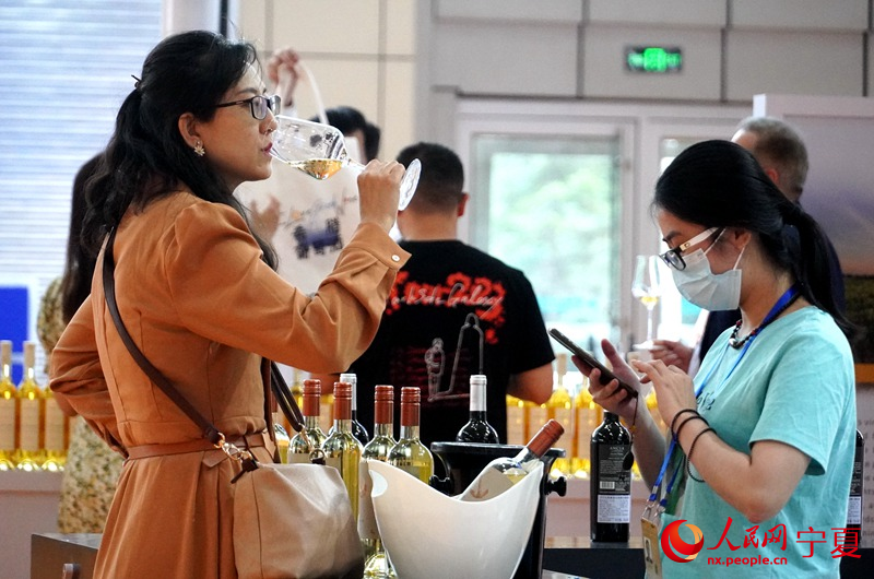 参会嘉宾品尝葡萄酒。人民网记者 高嘉蔚摄